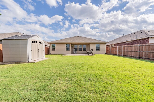 rear view of house featuring a fenced backyard, a storage unit, and a patio