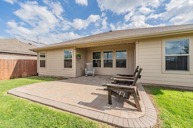 back of house featuring fence, a patio, and a yard
