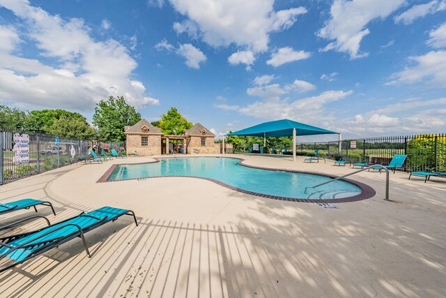 pool featuring fence and a patio area