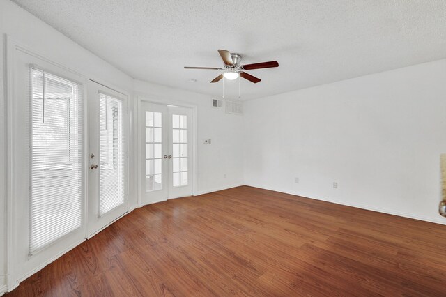 unfurnished room with baseboards, a ceiling fan, a textured ceiling, and wood finished floors