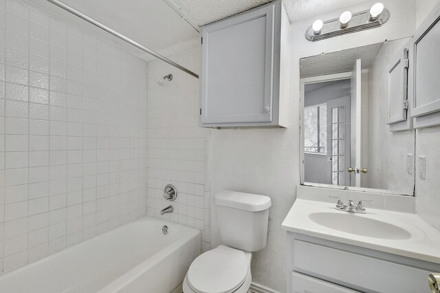 full bath with toilet, a textured ceiling, bathtub / shower combination, and vanity