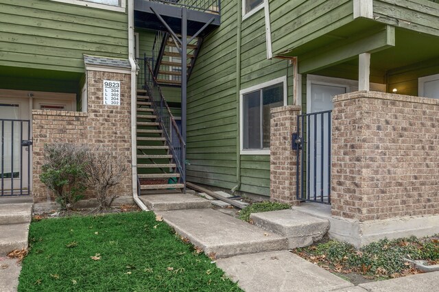 property entrance with brick siding and a gate