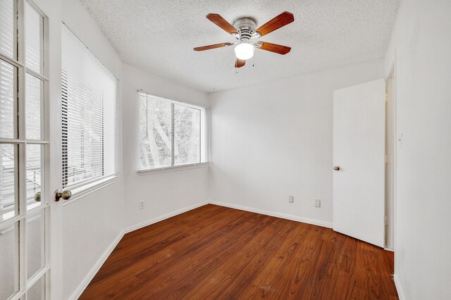 empty room with baseboards, a textured ceiling, ceiling fan, and wood finished floors