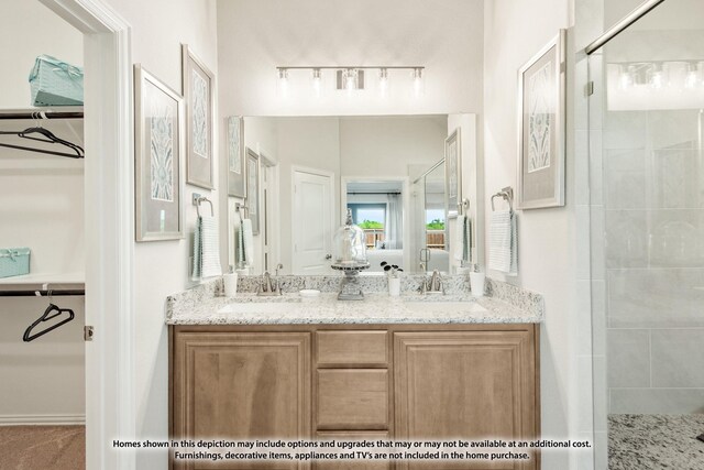 bathroom featuring double vanity, a shower stall, and a sink