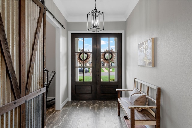 doorway to outside featuring french doors, dark wood-style flooring, a barn door, baseboards, and a notable chandelier