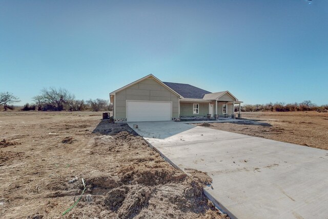 single story home featuring an attached garage, driveway, and a porch