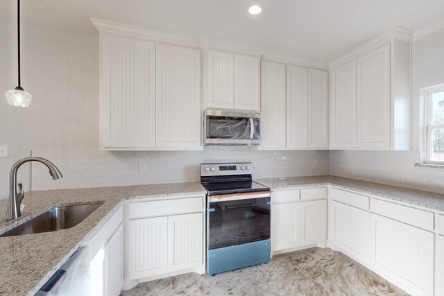 kitchen featuring white cabinets, appliances with stainless steel finishes, light stone counters, a sink, and backsplash