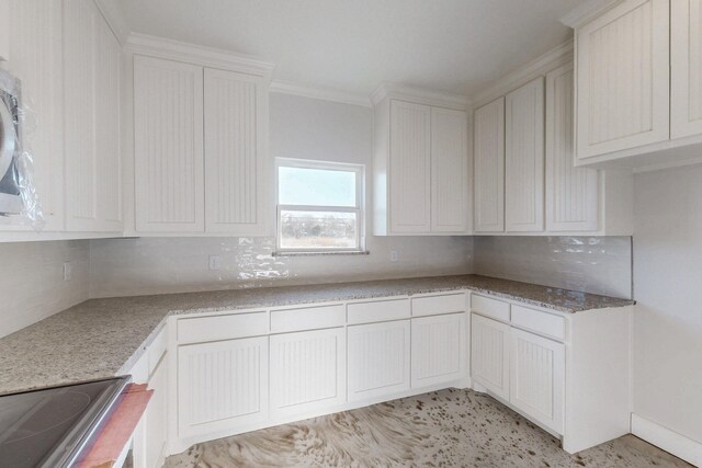 kitchen with cooktop, white cabinets, ornamental molding, and backsplash