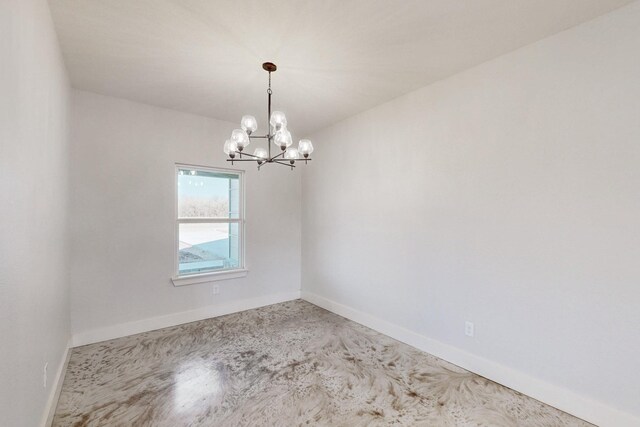 empty room with baseboards and a notable chandelier