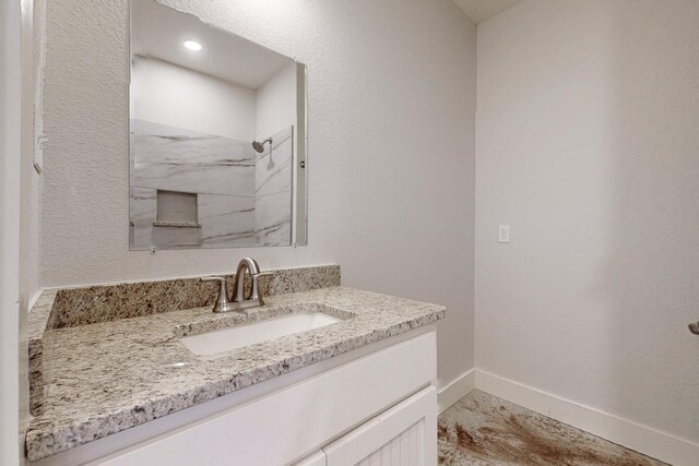 bathroom with a marble finish shower, baseboards, vanity, and marble finish floor