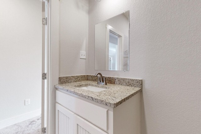 bathroom with vanity and a textured wall