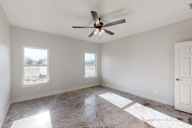carpeted spare room featuring baseboards, a ceiling fan, and visible vents