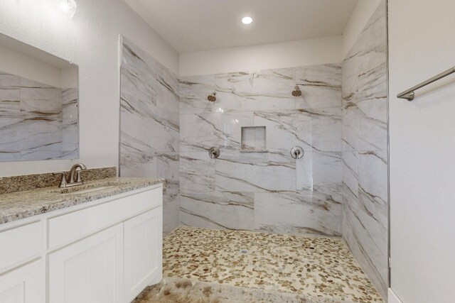 full bathroom with recessed lighting, a marble finish shower, and vanity