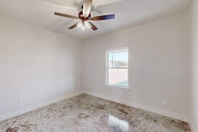 unfurnished room featuring a ceiling fan and baseboards