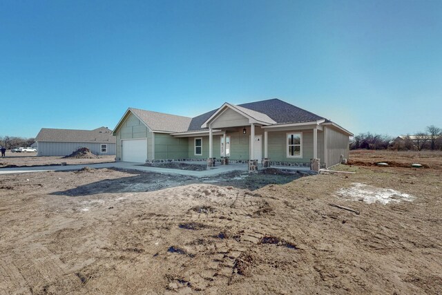 view of front of property with an attached garage, covered porch, and driveway