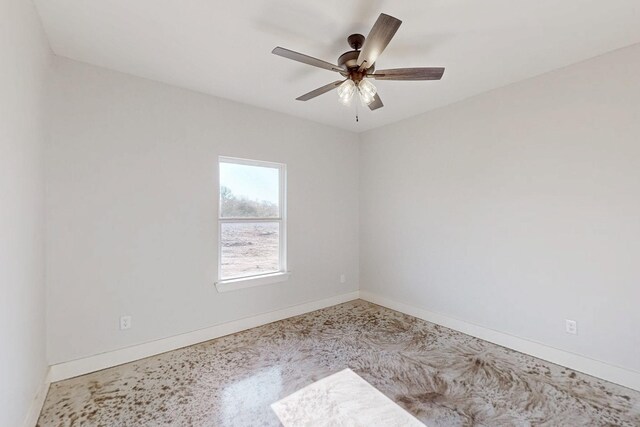 unfurnished room featuring a ceiling fan and baseboards