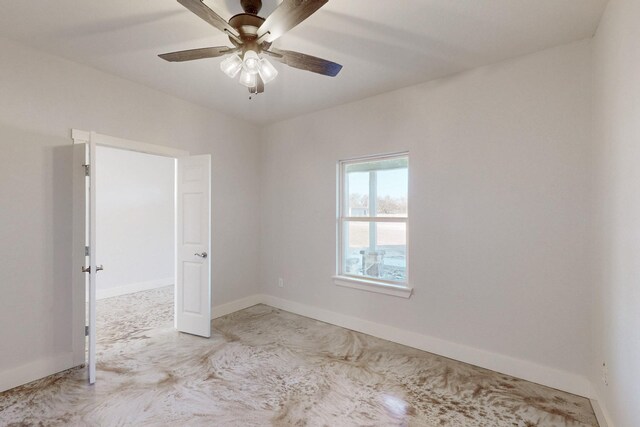 spare room with baseboards and ceiling fan