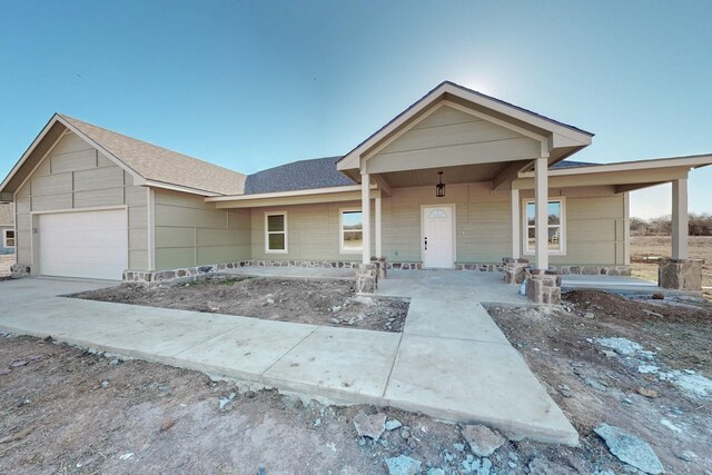 view of front of property featuring an attached garage and roof with shingles