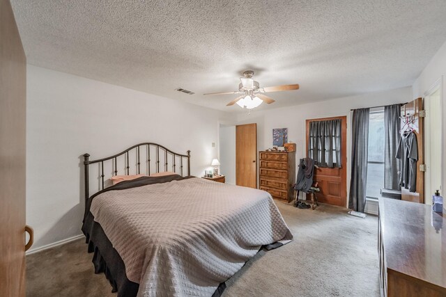 bedroom with a textured ceiling, carpet, a ceiling fan, baseboards, and visible vents
