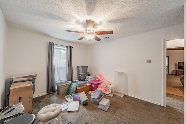 interior space with a ceiling fan, a textured ceiling, and visible vents