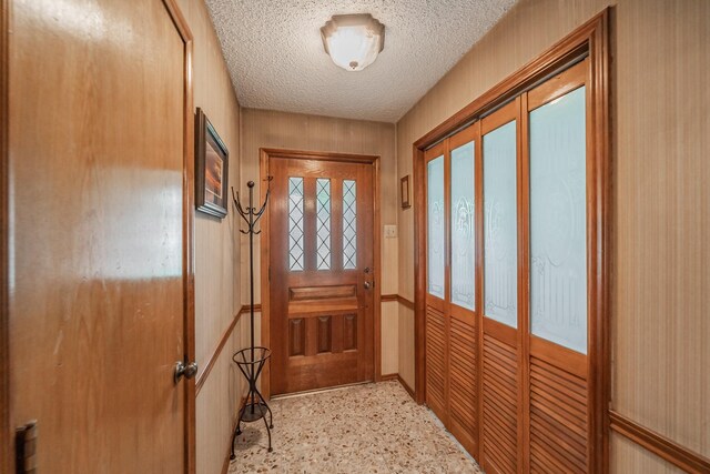 entryway with a textured ceiling and light speckled floor