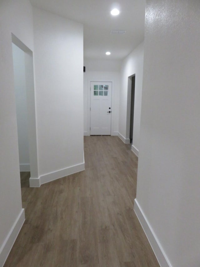 corridor with recessed lighting, baseboards, and wood finished floors