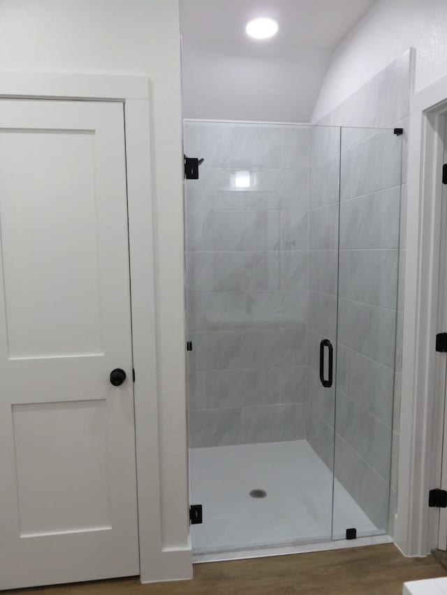 bathroom featuring a shower stall and wood finished floors