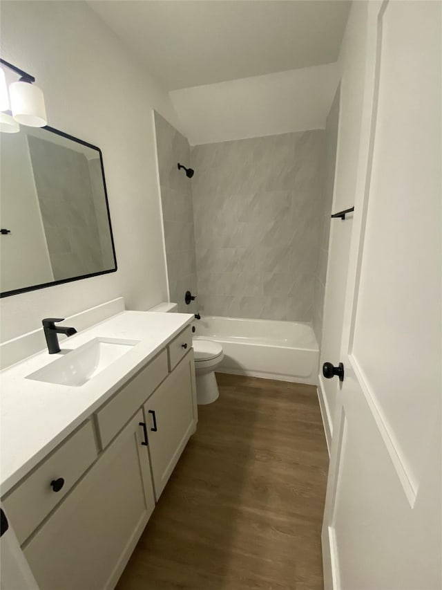 full bath with toilet, wood finished floors, shower / bathing tub combination, and vanity