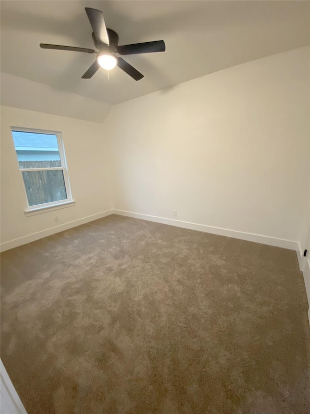 unfurnished room with carpet floors, ceiling fan, vaulted ceiling, and baseboards
