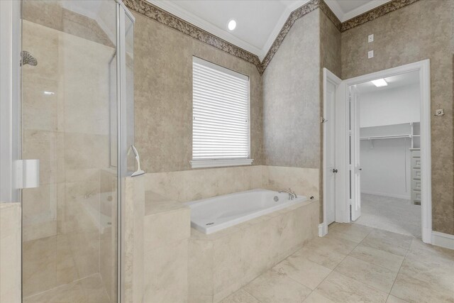 bathroom with crown molding, a bath, and a shower stall