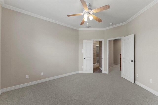 unfurnished bedroom with crown molding, ceiling fan, carpet floors, baseboards, and visible vents