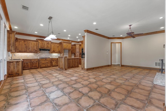 kitchen with a sink, crown molding, brown cabinets, and visible vents