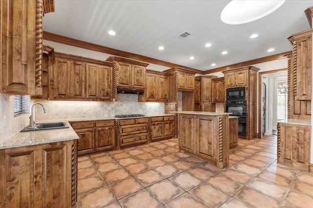 kitchen featuring crown molding, brown cabinets, visible vents, and a sink
