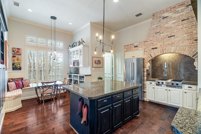kitchen with dark wood-style flooring, visible vents, white cabinets, dark stone counters, and stainless steel appliances