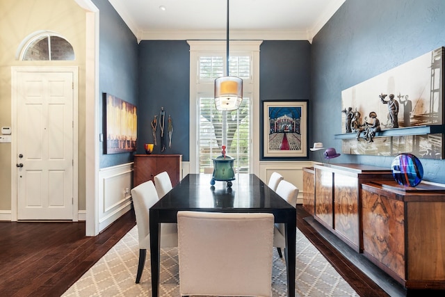 dining area featuring ornamental molding, a wainscoted wall, and dark wood-type flooring
