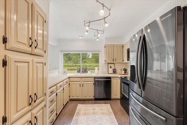 kitchen with track lighting, light countertops, a sink, dark wood finished floors, and appliances with stainless steel finishes