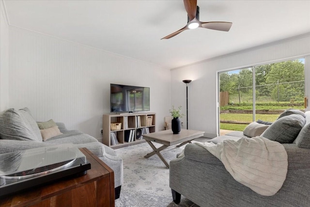 living room featuring crown molding and a ceiling fan