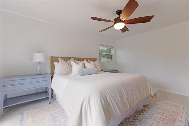 carpeted bedroom with ornamental molding and ceiling fan