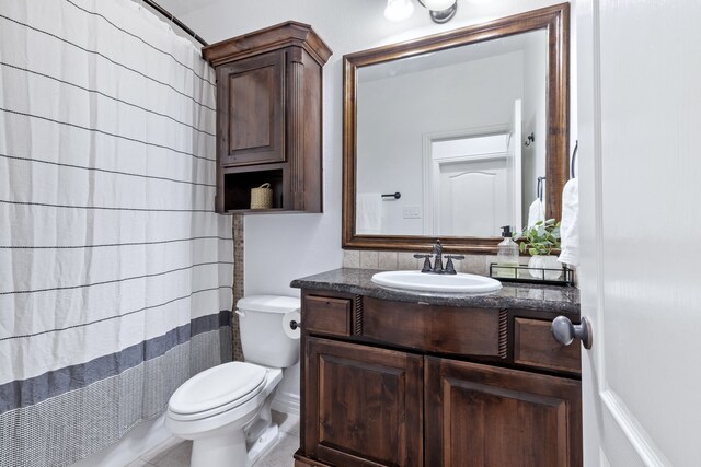 bathroom with toilet, curtained shower, and vanity