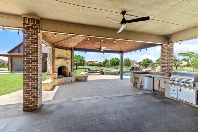 view of patio / terrace with fence, ceiling fan, area for grilling, an outdoor stone fireplace, and a grill
