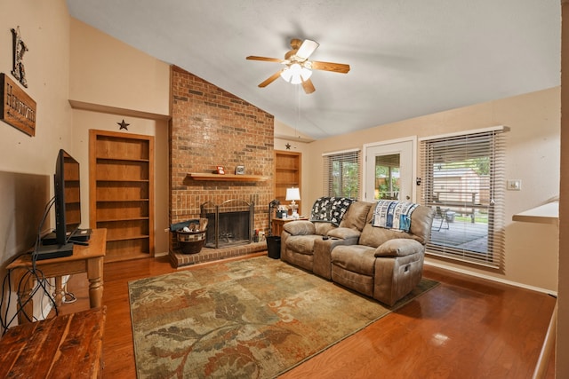 2609 Kimberly Dr, Garland, TX 75040 - living area with a brick fireplace, a ceiling fan, vaulted ceiling, and wood finished floors