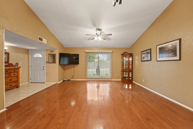 2609 Kimberly Dr, Garland, TX 75040 - unfurnished living room featuring ceiling fan, visible vents, wood finished floors, baseboards, and lofted ceiling