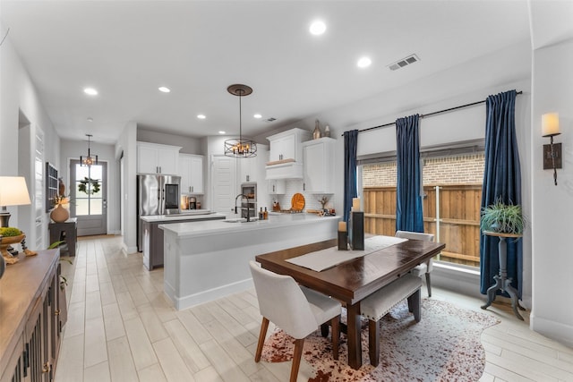 dining space featuring visible vents, baseboards, a notable chandelier, recessed lighting, and light wood-style flooring