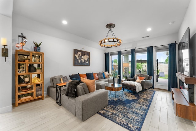 living room featuring visible vents, recessed lighting, light wood-style flooring, and an inviting chandelier