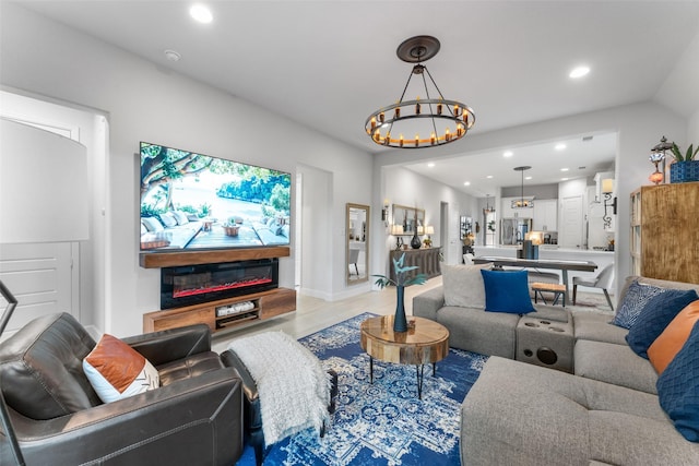 living room with recessed lighting, an inviting chandelier, and light wood finished floors