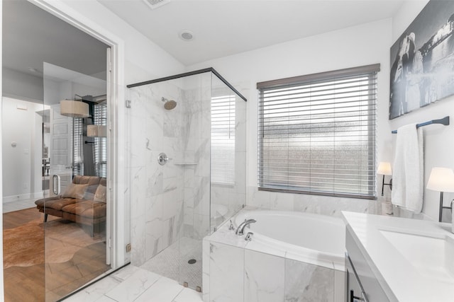 bathroom featuring vanity, a shower stall, and a garden tub