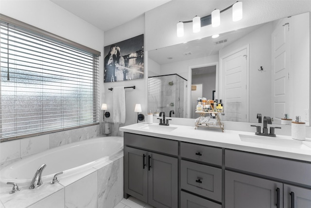 full bath with double vanity, a shower stall, a sink, and a bath