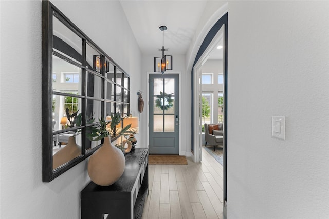 doorway with a notable chandelier and wood finished floors