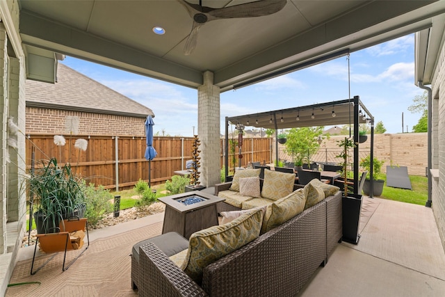 view of patio / terrace featuring a fenced backyard, an outdoor living space with a fire pit, and a ceiling fan