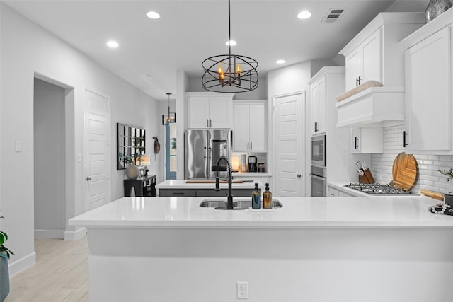 kitchen with a notable chandelier, light countertops, stainless steel appliances, recessed lighting, and tasteful backsplash
